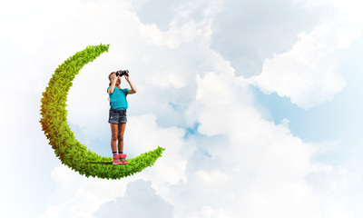 Concept of careless happy childhood with girl on green moon