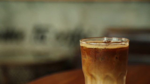 Close up shot of a coffee frappe being stirred. Coffee frappe is a cold variation of instant coffee drink