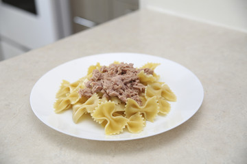 Farfalle pasta with tuna in a cozy kitchen
