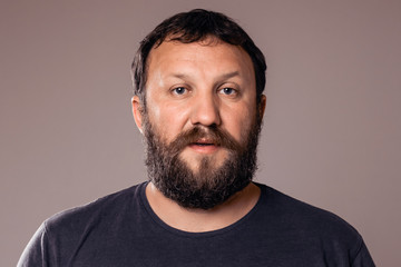 Obraz premium Handsome bearded man in blue t-shirt looking at camera.