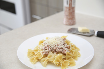 Farfalle pasta with tuna in a cozy kitchen
