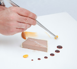 Cook using pincers to decorate dessert