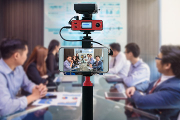 Closeup smart mobile phone taking Live of asian Business team having video conference,Camera for...