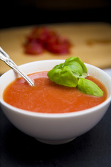 Tomato and Basil Soup in a White Ceramic Bowl in a Dark Environment