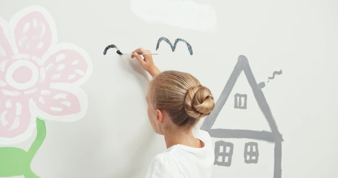 Girl drawing birds on the wall picture