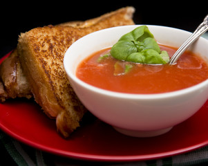 Tomato and Basil Soup in a White Ceramic Bowl in a Dark Environment