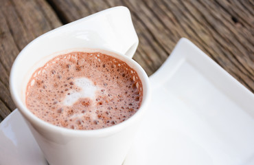 Cup of cocoa on white plate