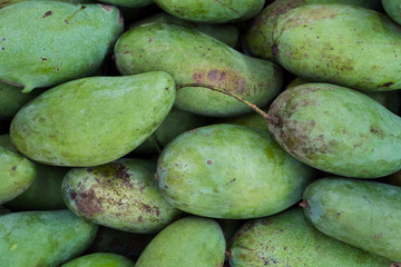 fresh asia tropical green mangoes fruit display and sell on organic outdoor farmer market.