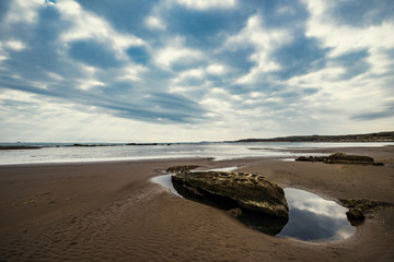 Fototapeta na wymiar Sandy beach with large stones