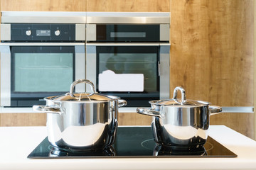 Metal Pot on induction hob in modern kitchen. modern kitchen pot cooking induction electrical stove hob concept