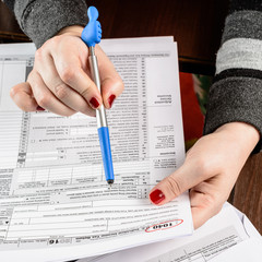 Naklejka premium Woman fills the tax form, working with tax documents. Form 1040 Individual Income Tax return form. United States Tax forms 2016/2017.