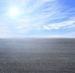 Broad asphalt road and blue sky and white clouds