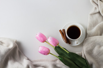 Cup of Coffee, Cinnamon, Scarf, Tulips on the White Background. Spring Concept. Flat lay, top view