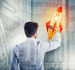 Businessman drawing a rocket. Concept of business improvement and enterprise startup