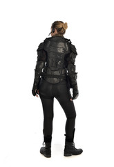 full length portrait of female  soldier wearing black  tactical armour  facing away from camera, isolated on white studio background.