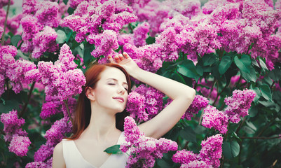 girl standing near lilac bushes in the park