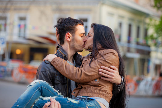 Young couple kissing on the street in springtime