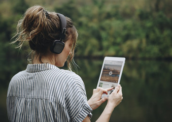 Woman alone in nature listening to music with headphones - obrazy, fototapety, plakaty