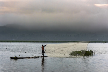 Black and white view of Fisherman in misty morning water dam