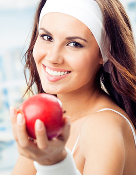 Woman with apple, at fitness center
