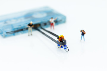 Fototapeta premium Miniature people: Man cycling to win on Compact Cassette. Image use for music , sport, business concept.