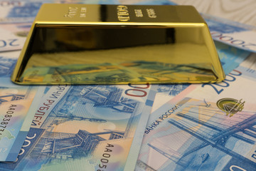 banknote and gold bullion isolated on black .