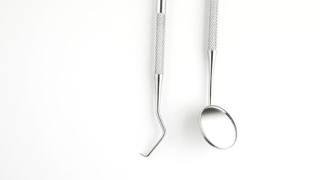 Set of dentist tools on white background: dentist mirror, forceps curved, explorer curved, dental explorer angular and explorer curved with chip, right. Dental Hygiene and Health conceptual image