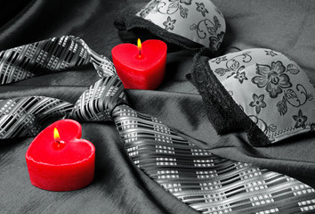 Close-up photo of grey men's tie and women's bra. Prelude of love. Romantic evening.