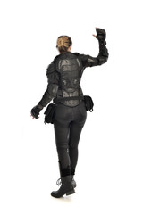 full length portrait of female  soldier wearing black  tactical armour  facing away from camera, isolated on white studio background.