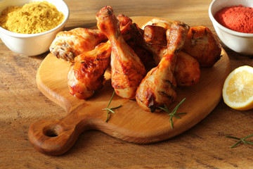 Grilled chicken legs on cutting board.Rustic dinner background