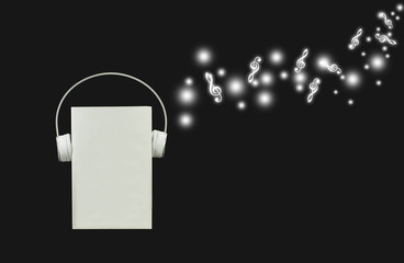 Headphones with blank books on a black background. Musical concept for relaxation