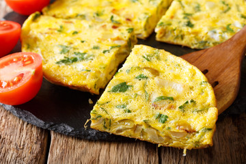 Egyptian cuisine: omelet Igga with greens, onions and tomatoes close-up. horizontal