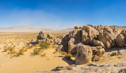 Fototapeta na wymiar Panorama of boulders above a vast plain of sand and desert in southern California.