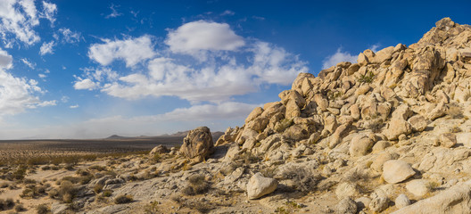 Hill composed of large sandstone boulders piled high in the sandy wilderness of a desert climate.