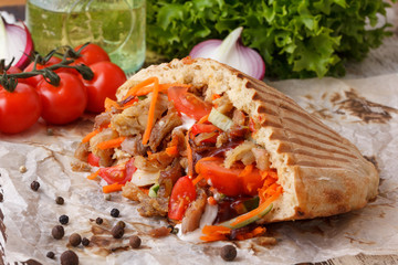 Juicy shaverma with chopped meat and fresh vegetables.