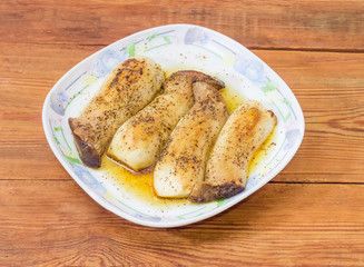 Baked Eringi mushrooms on dish on the rustic wooden table