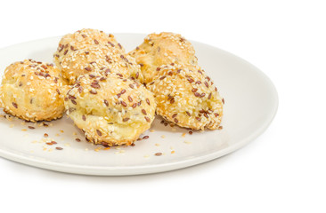 Savory profiteroles sprinkled with flax seeds and sesame seeds closeup