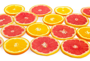 Round slices of oranges and red grapefruits on white background