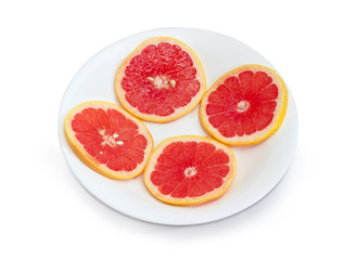 Fototapeta na wymiar Round slices of the red grapefruit on a white dish
