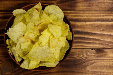 Plate of potato chips on wooden table