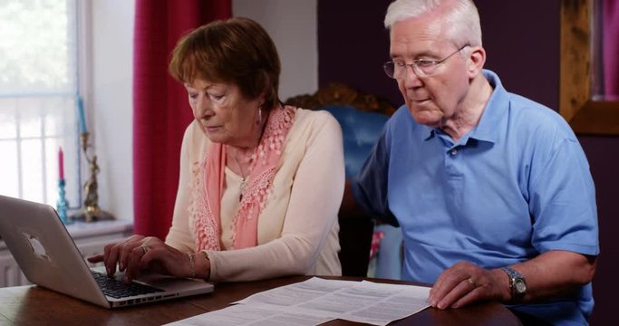 4k, Mature Couple Paying Their Household Bills Online On A Laptop.