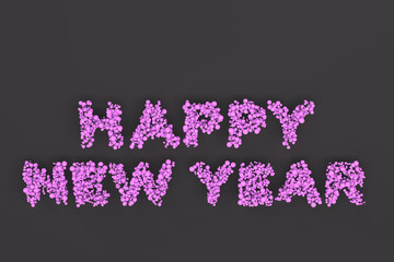 Happy New Year words from violet balls on black background