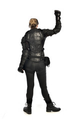 Fototapeta na wymiar full length portrait of female soldier wearing black tactical armour facing away from camera, isolated on white studio background.