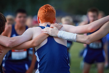 Boys on cross country team in a huddle