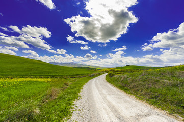 Fototapeta na wymiar Dirt road between meadows in Italy