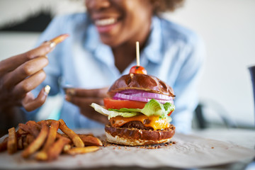 african american woman with vegan meatless burger meal