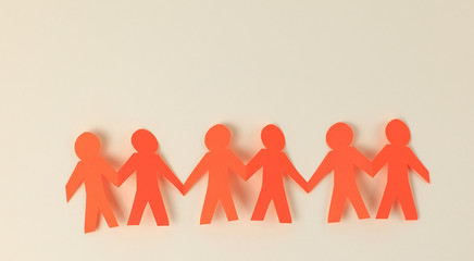 four paper men taking each other's hands