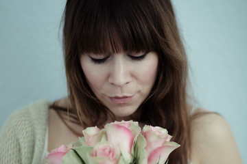 Portrait of woman looking to a bouquet of roses