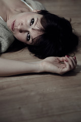 Pretty woman lying on floor looking into camera
