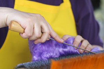 Felting wool. The step of combing the material in a special carding machine.
